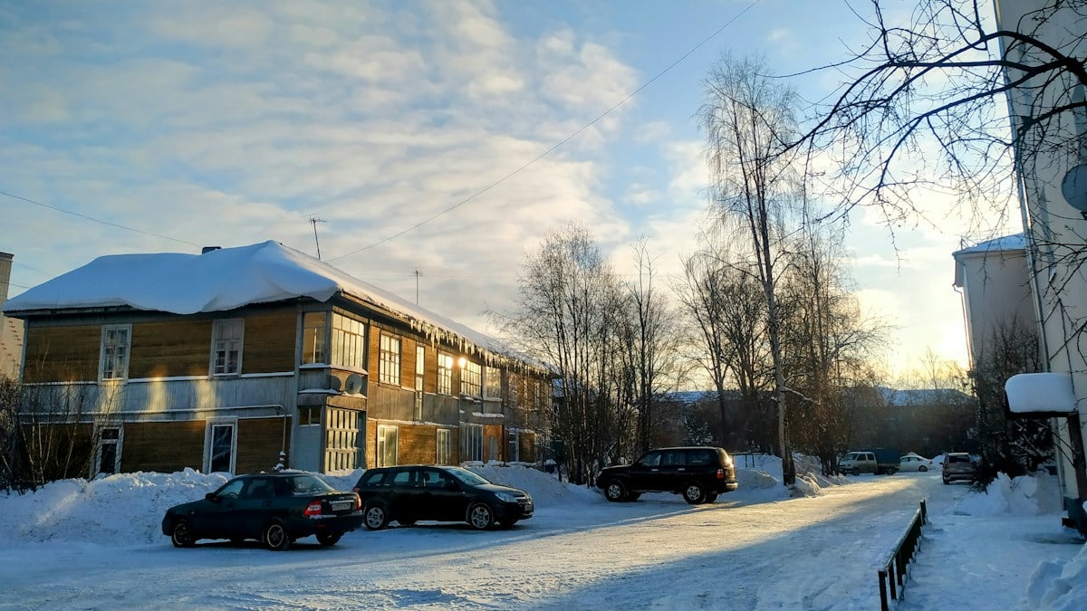 cars parked on the side of a snow covered road